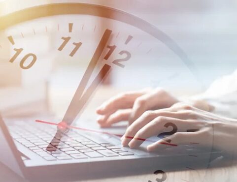 Hands typing on laptop, clock overlayed.