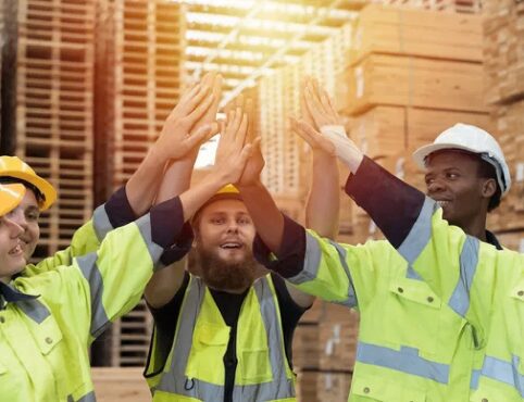 Construction workers celebrating with high fives.